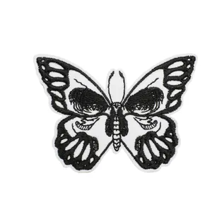 Écusson brodé papillon noir et blanc avec motif tête de mort gothique sur fond blanc