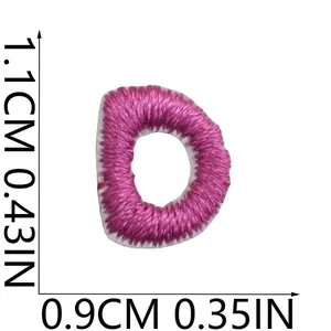 Macro view of pink embroidered letter D patch with size measurements 1.1cm x 0.9cm