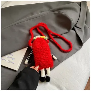 Close-up of a handmade red knitted funny shoulder bag with unique character legs.