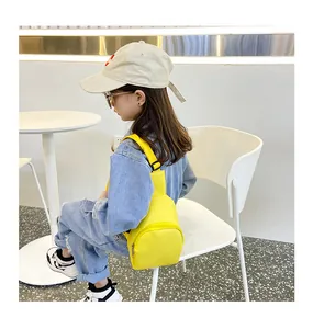 Kleines Mädchen trägt eine leuchtend gelbe PU-Leder-Brusttasche in modernem Stil