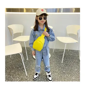 Leuchtend gelbe PU-Leder-Kindertasche, getragen von einem kleinen Mädchen in Denim.