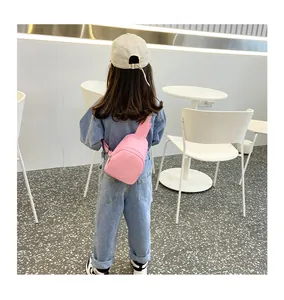 Rückansicht eines Mädchens mit einer rosa PU-Leder-Umhängetasche in einem modernen Café-Ambiente.