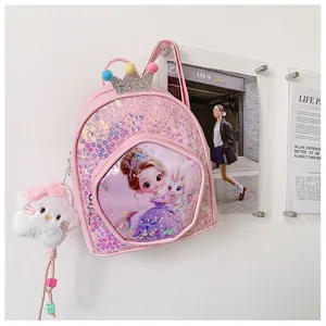 Detail view of pink sequined princess backpack with crown decoration and plush cat charm.