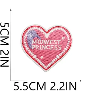 Detaillierte Nahaufnahme des rosa Herz-Stickpatches mit dem Text Midwest Princess