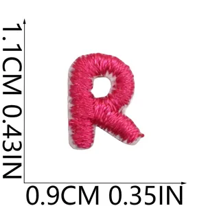 Detailed macro shot of a small pink embroidered letter R patch with size measurements