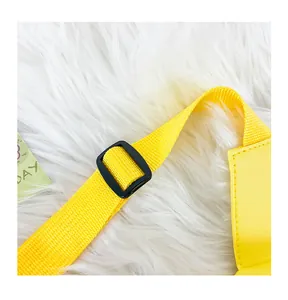 Detailaufnahme des verstellbaren gelben Nylongurts einer süßen PU-Ledertasche für Kinder.