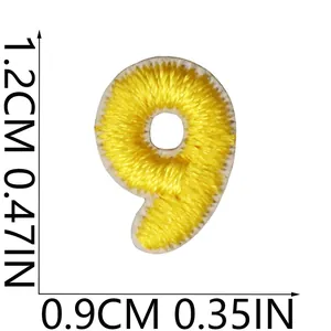 Macro view of yellow number 9 embroidered patch with small size measurement markers