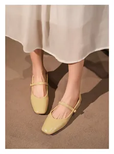 Vista detallada de elegantes zapatos Mary Jane amarillos de punta cuadrada con hebilla.