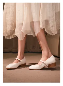 Détail d'élégantes chaussures Mary Jane crème à bout carré français avec talon bloc brun