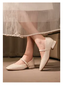 Primer plano de una modelo con zapatos Mary Jane color crema con tacón de bloque