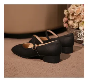 Détail arrière de chaussures Mary Jane noires avec bride et boucle dorée élégante.
