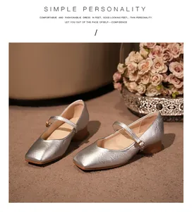 Chaussures Mary Jane argentées à bout carré et bride sur un sol texturé beige