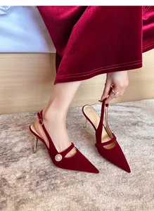 Vista detallada de elegantes zapatos destalonados de terciopelo rojo con hebilla de perlas
