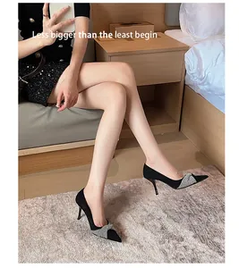 Elegant black suede stiletto heels featuring sparkly rhinestone bow detail on model