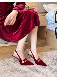 Vista detallada de los elegantes zapatos destalonados de ante rojo con perlas finas