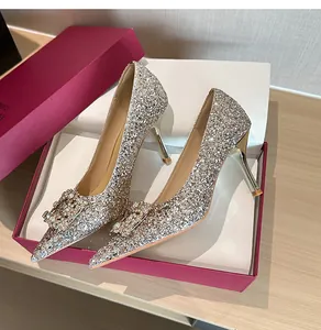 Close-up of champagne glitter high heels with sparkling rhinestone buckle