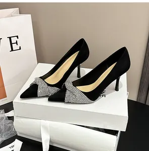 Elegant black suede stiletto high heels featuring a sparkling rhinestone cross detail