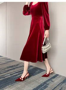 Elegantes zapatos destalonados de terciopelo granate con un detalle clásico de perla blanca.
