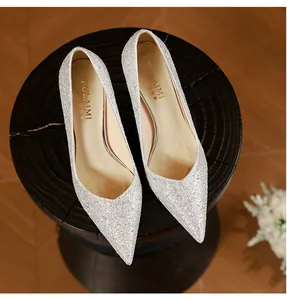 Close-up view of silver glitter wedding shoes with pointed toe and brand logo on insole