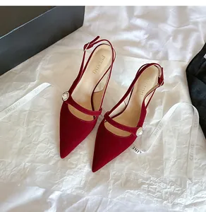 Vista de detalle de elegantes tacones de terciopelo rojo con tira de perlas