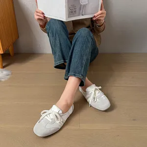 Nahaufnahme von weißen und grauen Leder-Ballerinas in einer Lifestyle-Umgebung