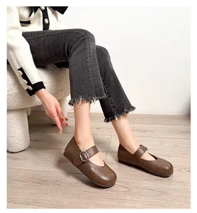 Elegante braune Mary Jane Ballerinas aus Leder, getragen von einem Modell in Jeans