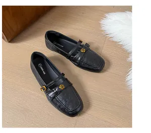 Exquisite detail of black leather Mary Jane loafers with a gold rose decoration