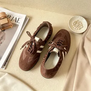 Detailansicht brauner Leder-Ballett-Sneaker mit weißen Streifen und elastischer Ferse.