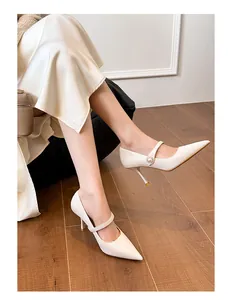 Vue détaillée de talons hauts blancs vintage à bout pointu avec une bride en perles élégante