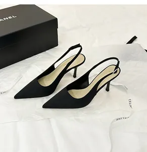 Elegantes zapatos de tacón destalonados en satén negro con punta fina y tacón de aguja.