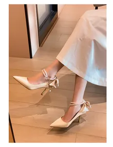 Elegantes zapatos de novia de satén francés con correas de perlas y lazos en el talón