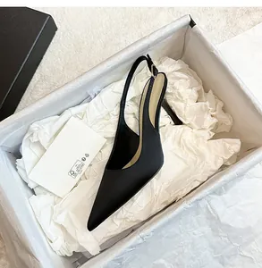 Elegante zapato stiletto destalonado de raso negro con punta fina en caja de zapatos