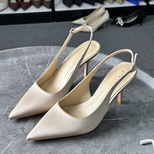 Vista lateral de elegantes zapatos destalonados de raso beige en una mesa de piedra