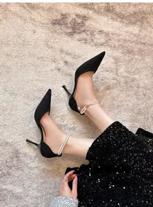 Close-up view of elegant black suede stiletto heels with pearl bead ankle straps