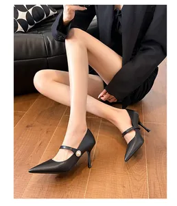 Escarpins Mary Jane noirs élégants à bout pointu avec boucle en perle portés par un mannequin