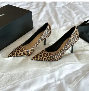 Elegante Stilettos mit Leopardenmuster und spitzer Kappe auf weißem strukturiertem Hintergrund