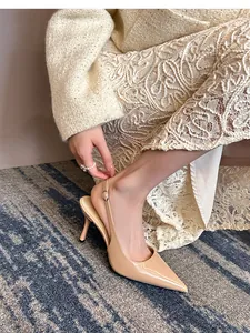 Side view of elegant nude patent leather pointed-toe slingback heels worn with a lace dress