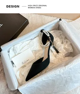 Elegant black suede pointed toe stiletto heels with pearl ankle straps in a white gift box