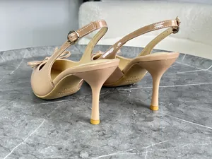 Dettaglio di décolleté slingback in vernice nude con elegante fiocco e tacco fine.
