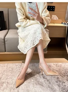 Elegant nude patent leather slingback high heels shown on a model in a lifestyle setting.