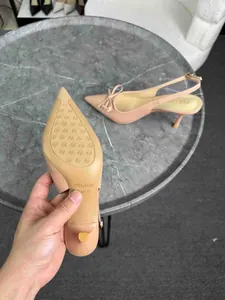 Dettaglio di eleganti décolleté nude slingback con fiocco e suola testurizzata.
