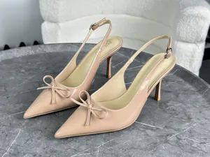 Vista dettagliata di eleganti décolleté beige in pelle verniciata con punta e fiocco