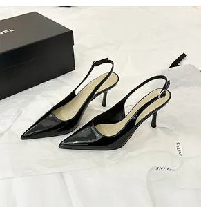 Close-up detail of elegant black patent leather pointed toe slingback high heels on white tissue