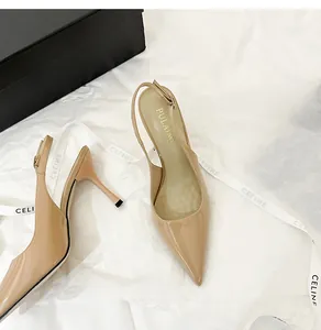 Detail view of beige patent leather slingback heels with pointed toe and stiletto heel