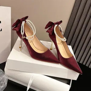 Elegantes zapatos de salón en satén burdeos con cadena de perlas y lazo para bodas