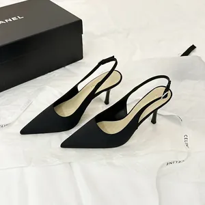Elegantes tacones de aguja slingback en satén negro con punta fina para un estilo sofisticado.