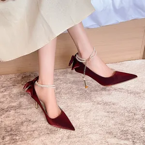 Elegantes zapatos de novia de satén burdeos con cadena de perlas y un lazo
