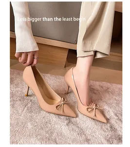 Detailaufnahme von beigen spitzen High Heels mit Schleife und Stilettoabsatz
