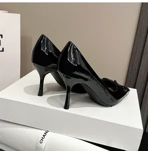 Detailansicht der eleganten schwarzen Lackleder-Stilettos mit spitzer Zehenpartie auf Box