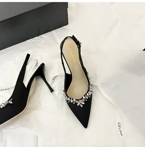 Dettaglio ravvicinato di tacconi in raso nero con eleganti decorazioni floreali in strass